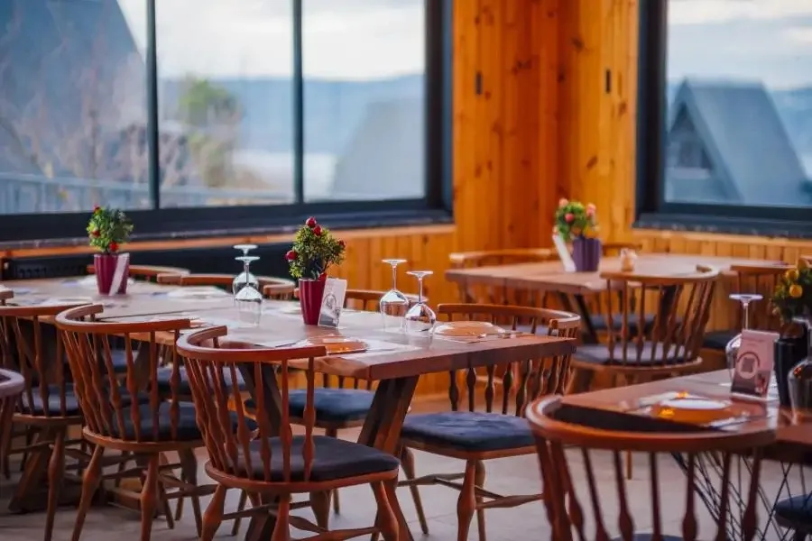 Sapanca My Resort Prive otel restoranında ahşap masalar ve çiçek arrangementları