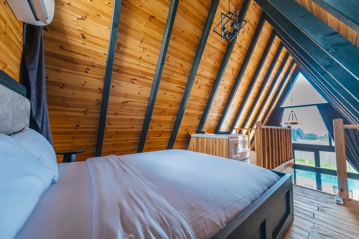 Sapanca My Resort Prive bungalov iç mekan görünümü, konforlu yatak ve doğal ahşap detaylar.